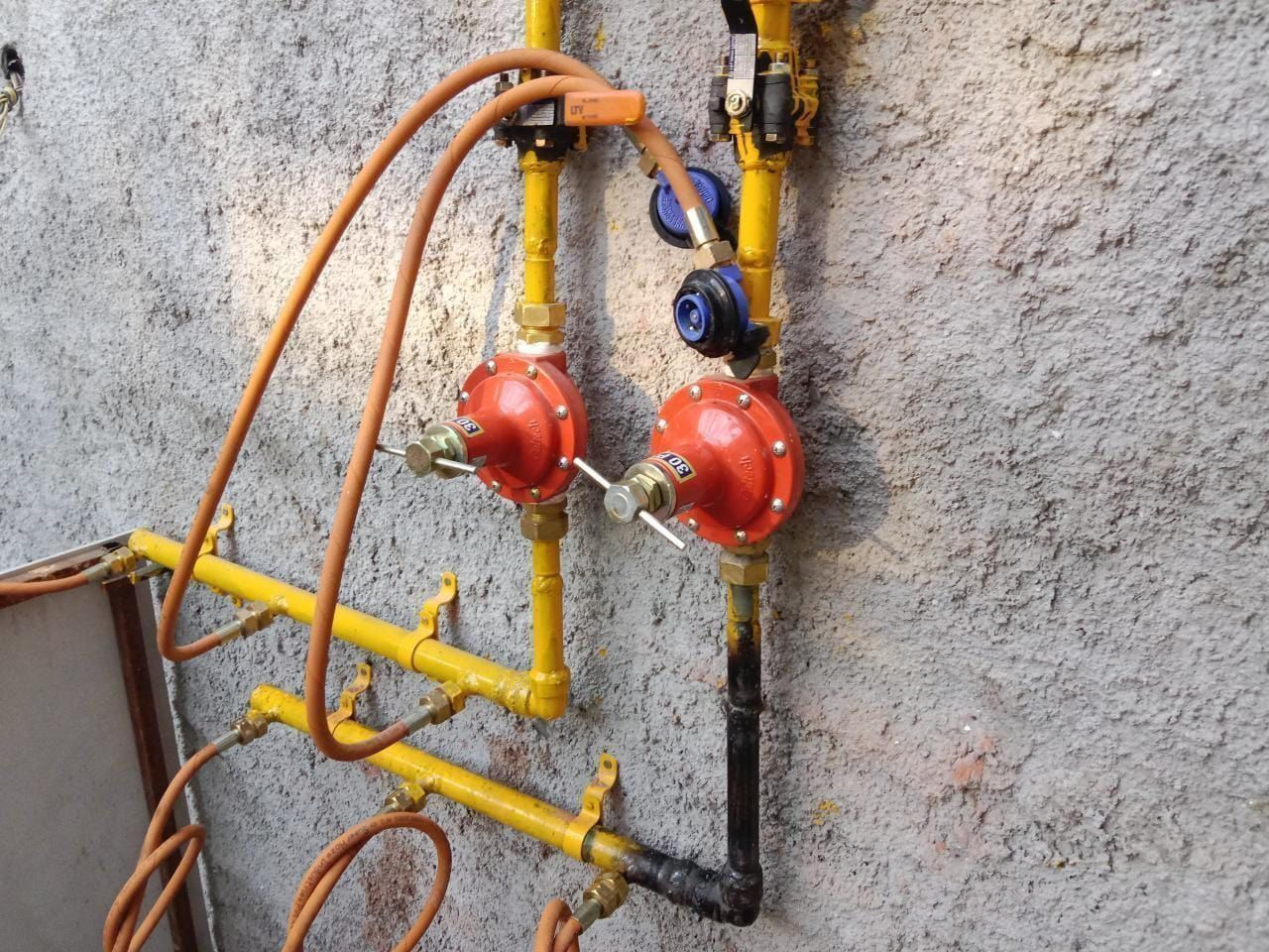 Gas pipeline manifold and regulator installation with yellow pipes and red pressure regulators